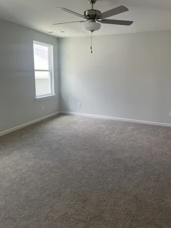 an empty room with a window and a fan
