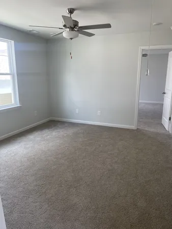 an empty room with a window and a fan