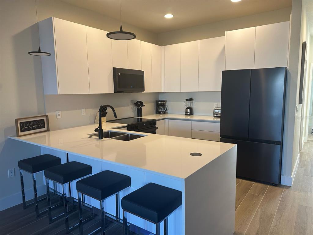 1422 Wanderlust Lane Clermont, FL 34714 - Photo 1 of 1 a kitchen with stainless steel appliances a refrigerator a sink a stove a table and chairs