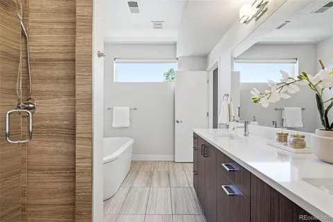 a spacious bathroom with a granite countertop sink a toilet a mirror and shower