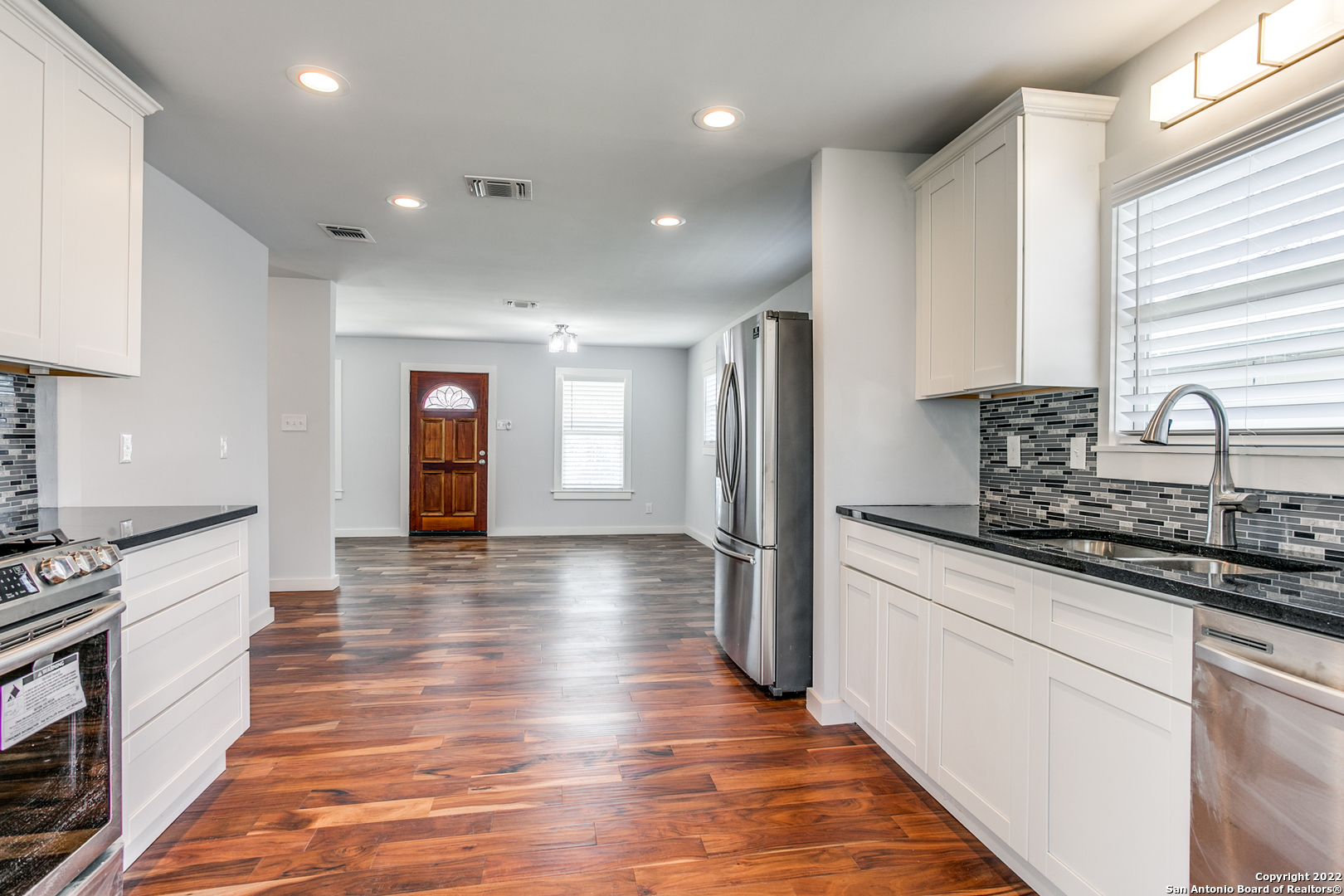 311 Clarence Street San Antonio, TX 78212 - Photo 15 of 23 a kitchen with stainless steel appliances granite countertop a refrigerator a stove and a wooden floors