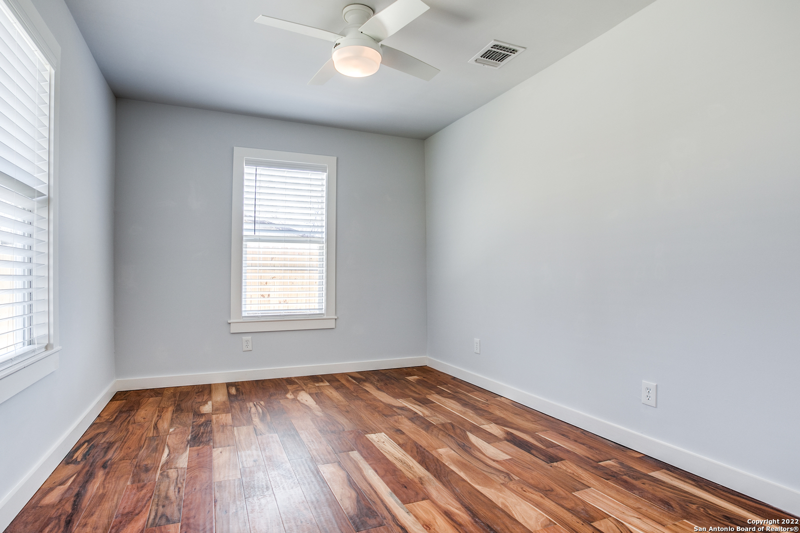 311 Clarence Street San Antonio, TX 78212 - Photo 9 of 23 an empty room with wooden floor and windows