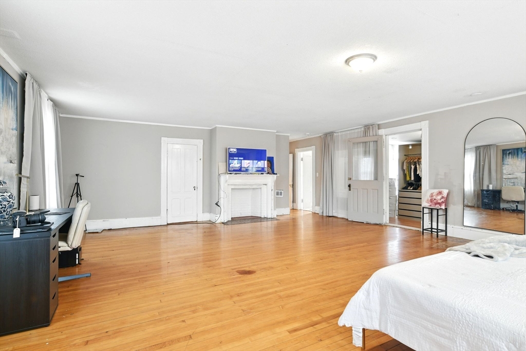 346 Maple Street Springfield, MA 01105 - Photo 29 of 36 a spacious bedroom with a bed and wooden floor