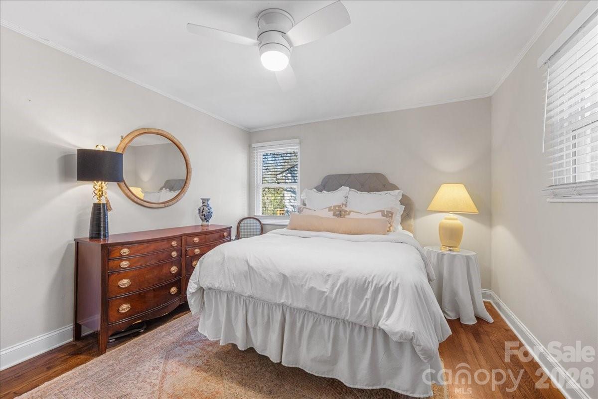 4922 Valley Stream Road Charlotte, NC 28209 - Photo 19 of 33 a bedroom with a bed a mirror on dresser and a chandelier