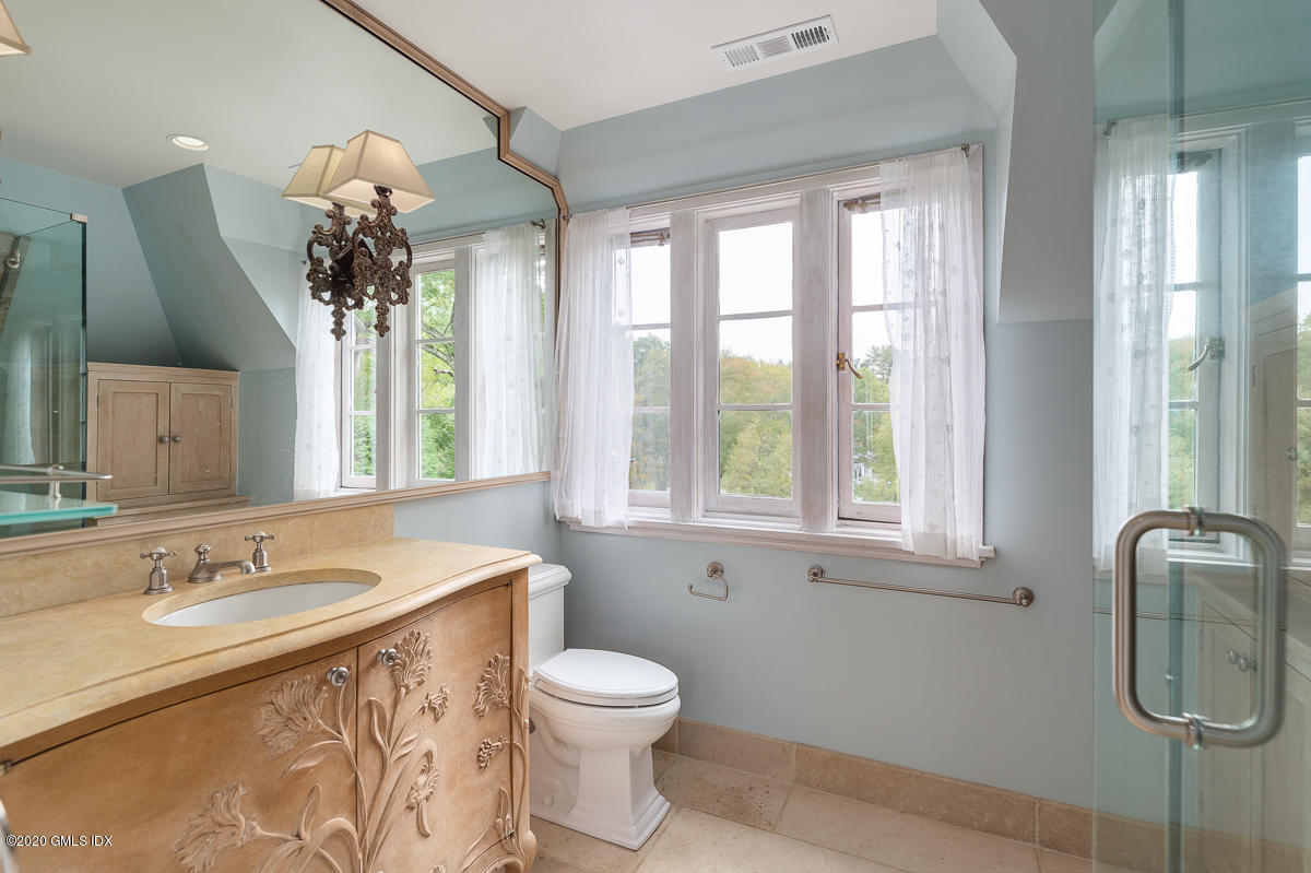 10 Frost Road Greenwich, CT 06830 - Photo 16 of 24 a bathroom with a granite countertop sink a toilet and a shower