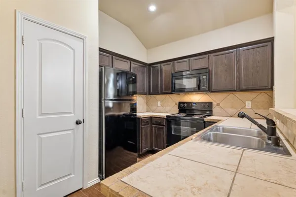 a kitchen with a refrigerator stove and cabinets