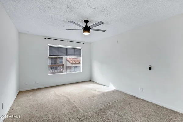 a view of a livingroom with a ceiling fan and kitchen