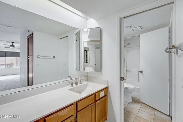 a bathroom with a granite countertop sink mirror vanity and toilet