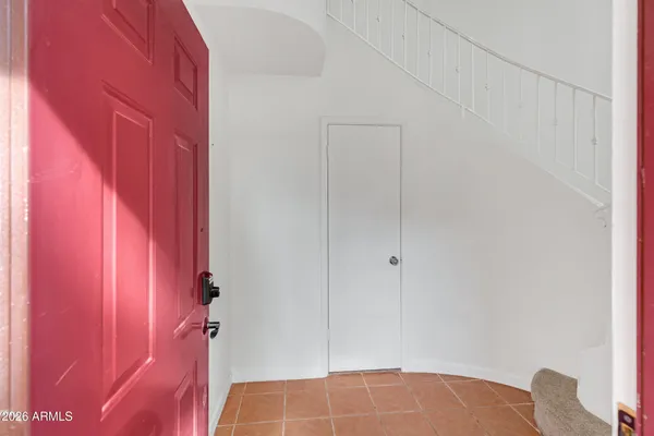 a view of an empty room with wooden floor and a ceiling fan