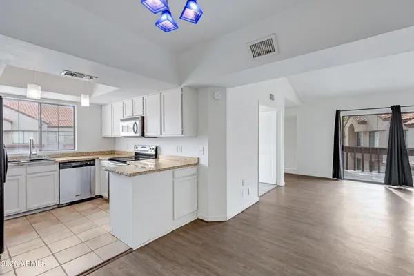 a kitchen with stainless steel appliances granite countertop a refrigerator and a sink