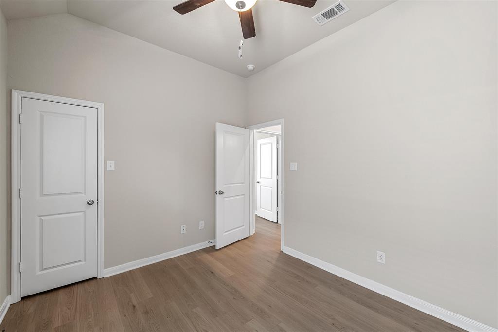 3224 Dottavio Road Lorena, TX 76655 - Photo 19 of 31 Spacious room featuring vaulted ceilings, wood-finish flooring, two-panel doors, and a ceiling fan with integrated lighting