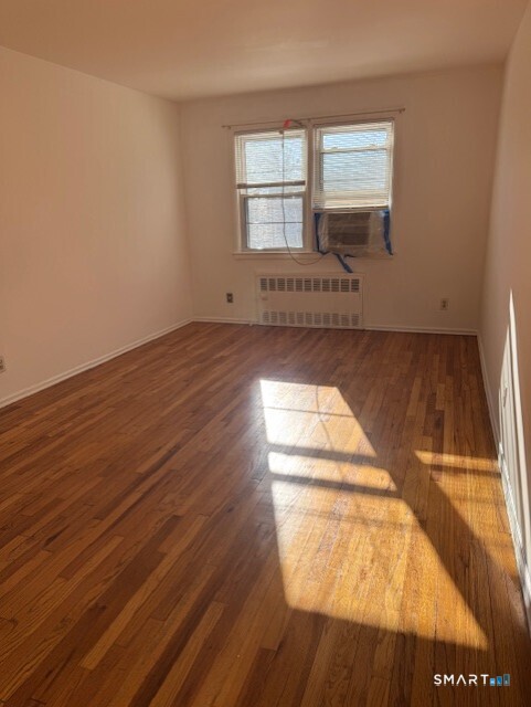 236 Glenbrook Road, Unit 12A Stamford, CT 06906 - Photo 12 of 18 a view of empty room with wooden floor and fan