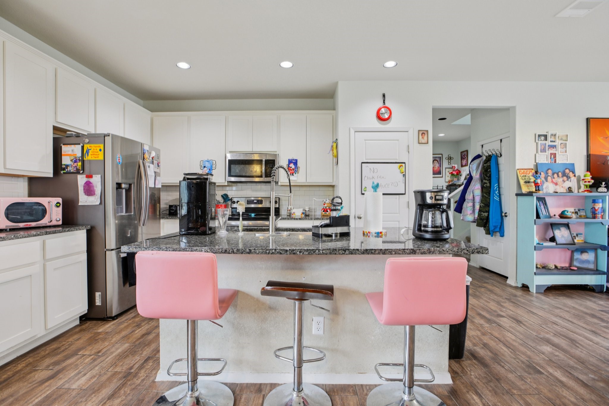 119 Saranac Drive Elgin, TX 78621 - Photo 14 of 41 a kitchen with stainless steel appliances kitchen island granite countertop a dining table chairs refrigerator and sink