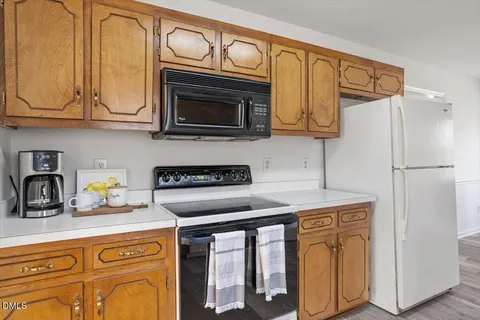 a kitchen with stainless steel appliances granite countertop a refrigerator stove top oven a sink and dishwasher