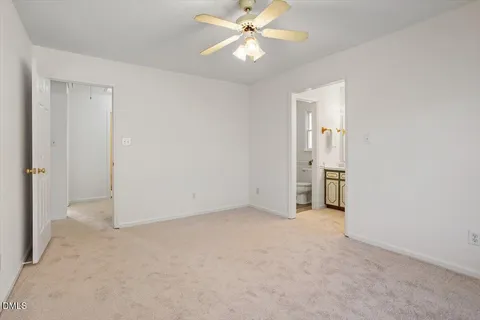 an empty room with closet and a ceiling fan