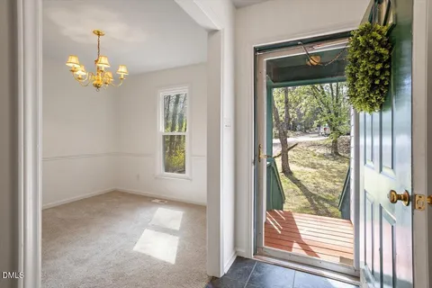 a view of a room that has a large window front door and wooden floor