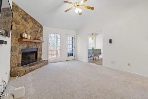 a view of an empty room with a fireplace and a window