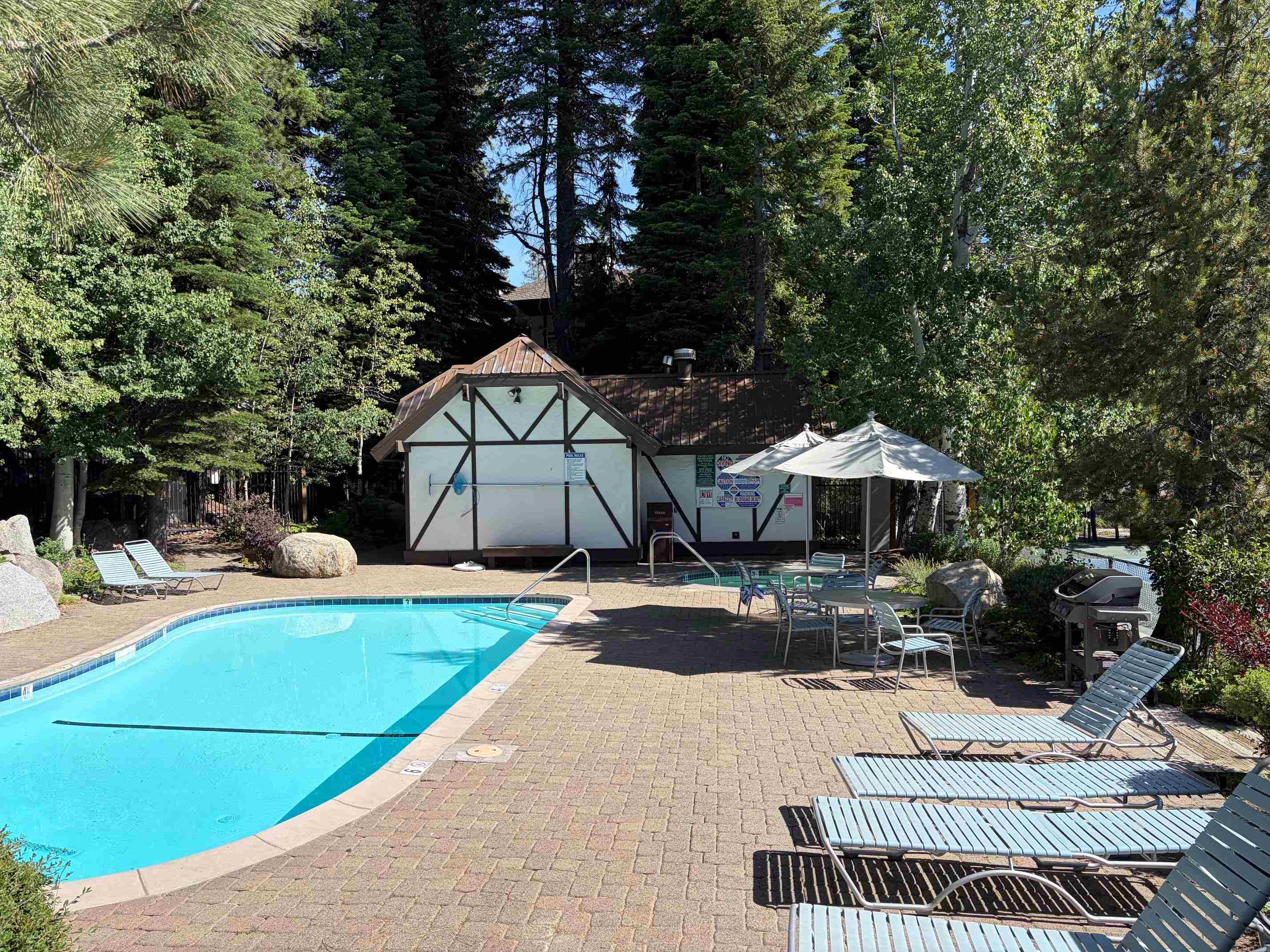 227 Olympic Vly Road, Unit 3 Olympic Valley, CA 96146 - Photo 3 of 5 a view of a patio with a table and chairs under an umbrella
