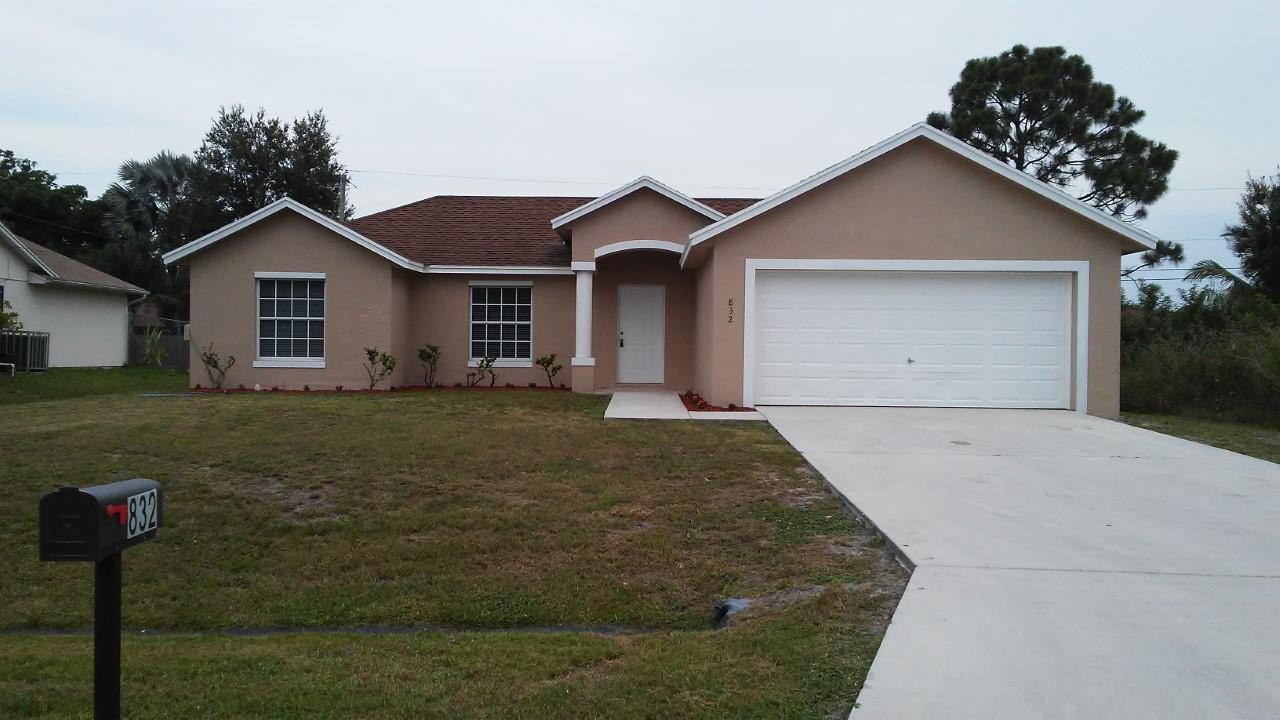 832 Southwest Duncan Terrace Port St. Lucie, FL 34953 - Photo 1 of 37 a view of a house with a yard and garage
