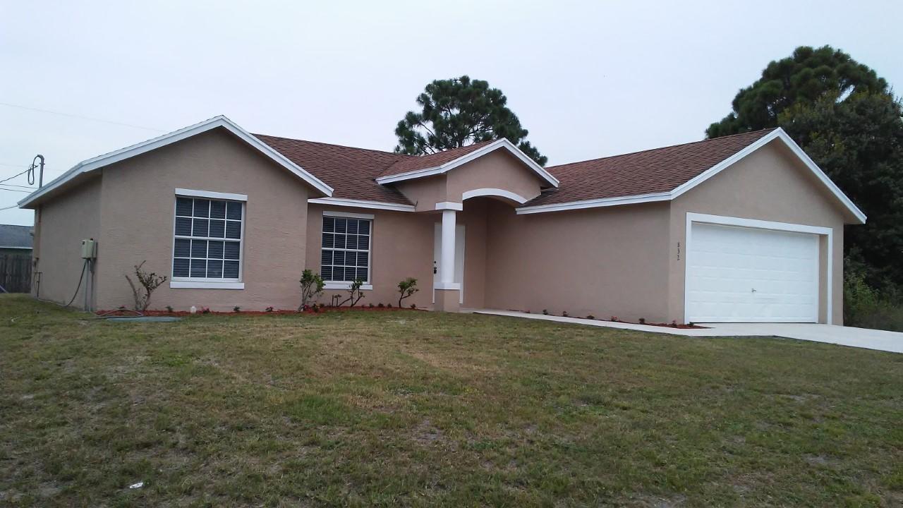 832 Southwest Duncan Terrace Port St. Lucie, FL 34953 - Photo 2 of 37 a front view of a house with a yard and garage