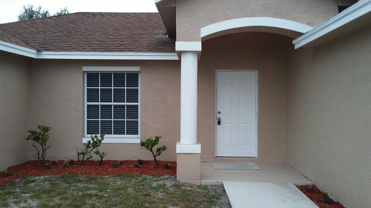 832 Southwest Duncan Terrace Port St. Lucie, FL 34953 - Photo 4 of 37 a front view of a house with a yard