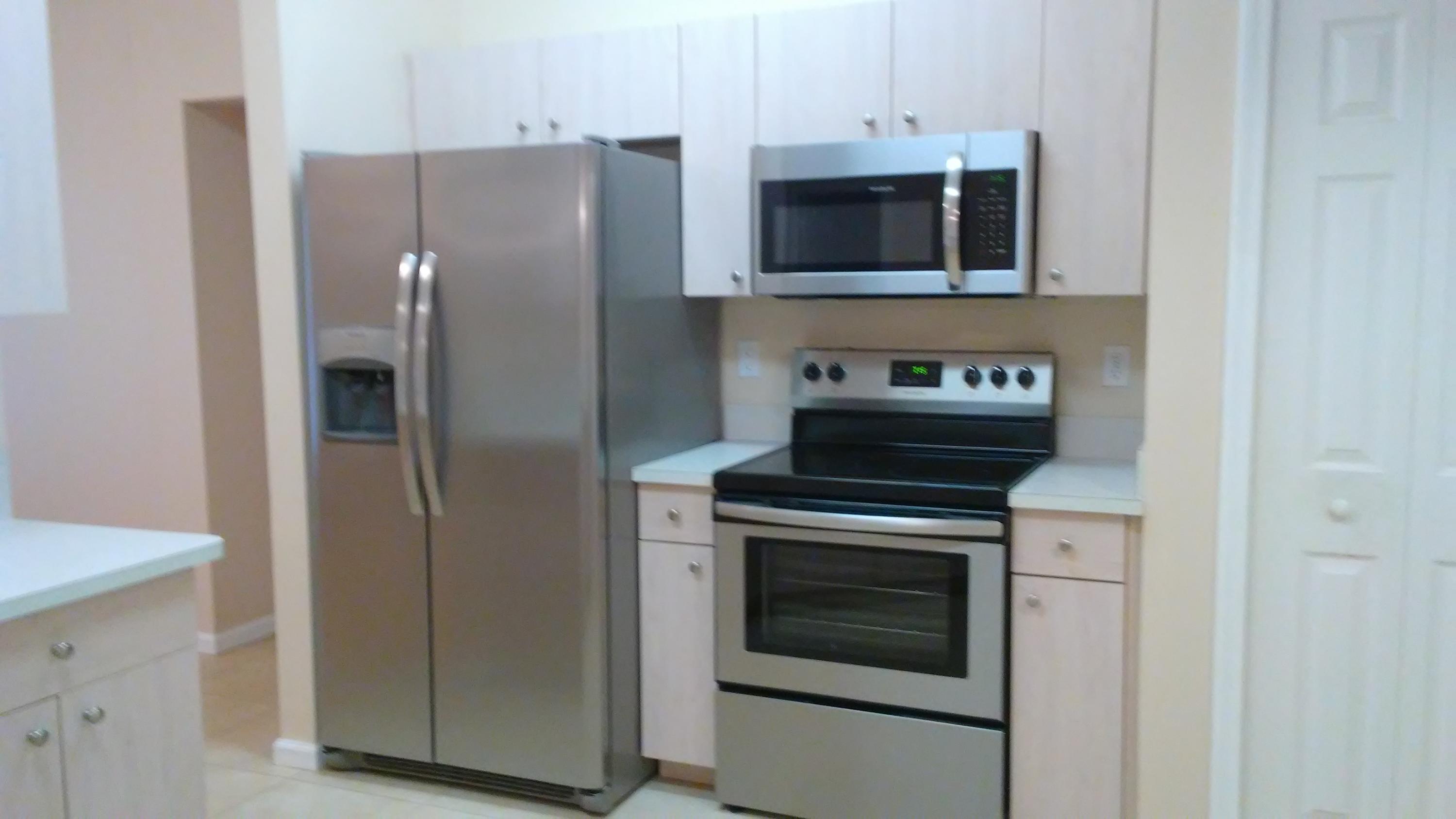 832 Southwest Duncan Terrace Port St. Lucie, FL 34953 - Photo 10 of 37 a kitchen with stainless steel appliances a stove microwave and refrigerator