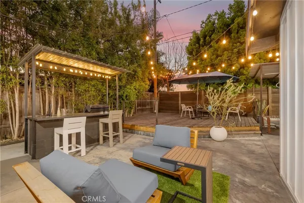 a view of a patio with couches table and chairs and potted plants