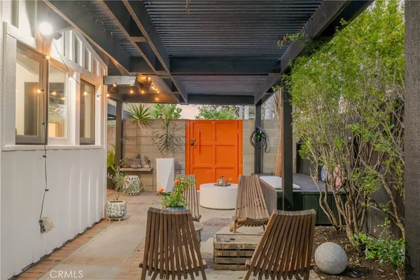a view of a chair and table in backyard of the house