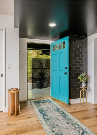 a view of a hallway with wooden floor and a living room