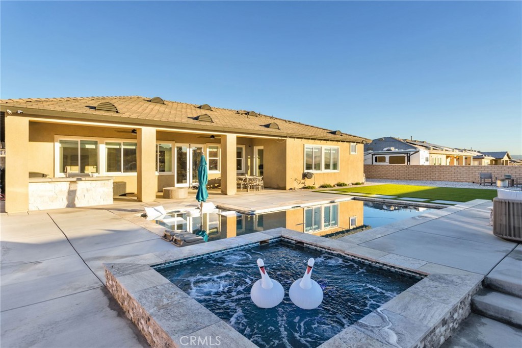 a front view of a house with swimming pool and a yard
