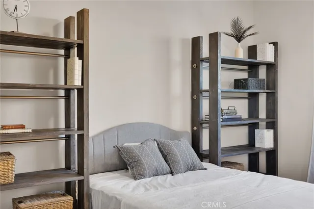 a bedroom with a bed and a chandelier fan