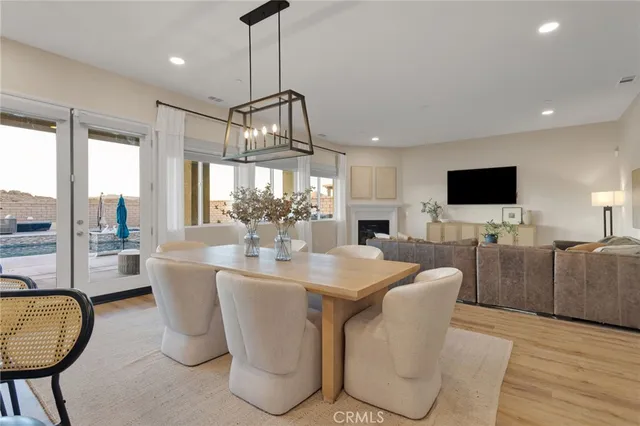a dining room with furniture a chandelier and wooden floor