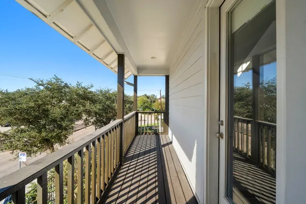 a view of balcony with wooden floor and fence