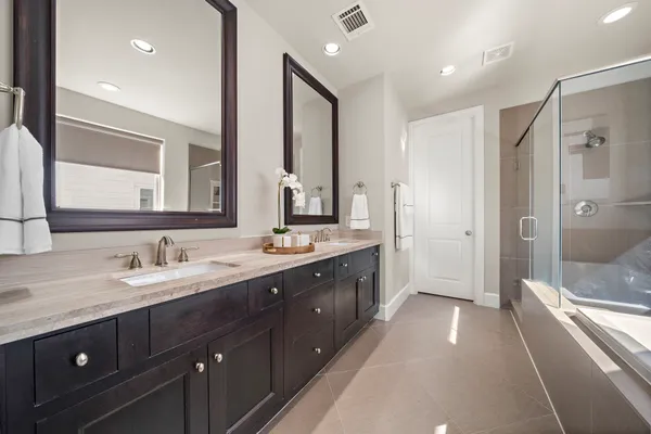 a spacious bathroom with a double vanity sink mirror double and shower