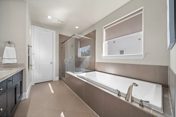 a bathroom with a tub sink and mirror