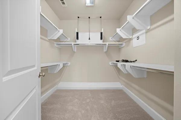 a view of walk in closet with empty racks