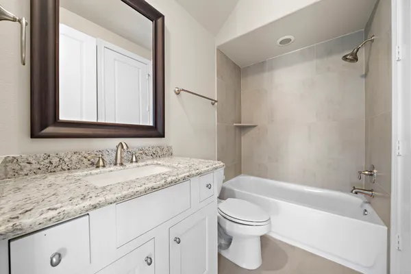 a bathroom with a granite countertop sink toilet and shower