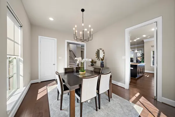 a view of a dining room with furniture a chandelier and wooden floor