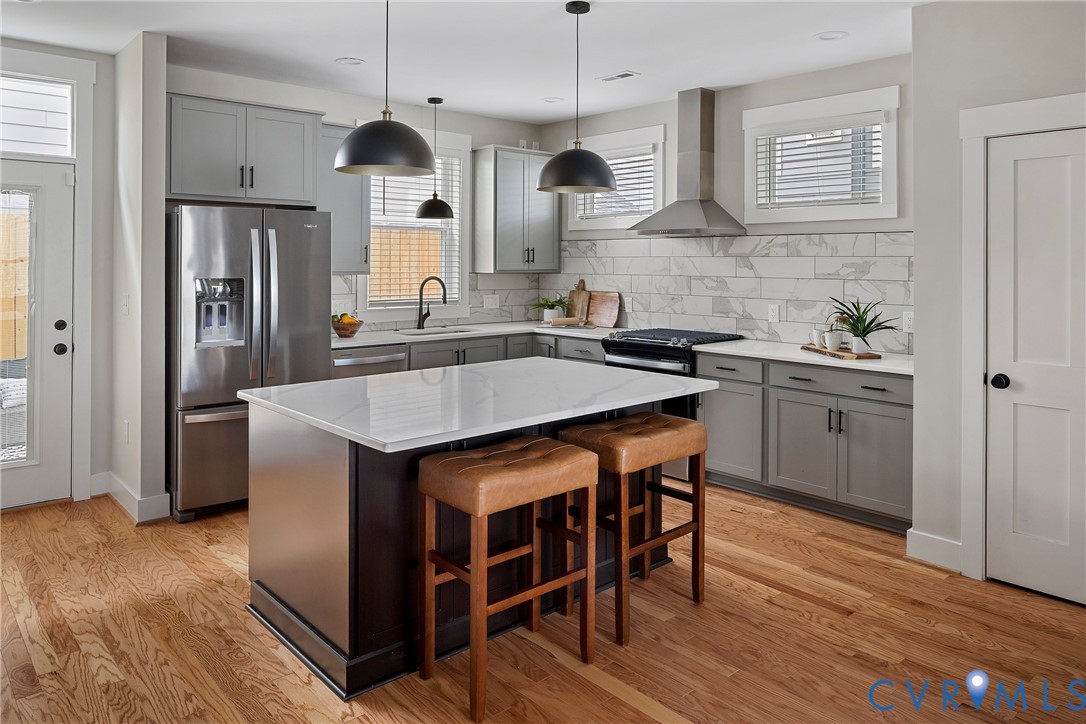 2909 R Street Richmond, VA 23223 - Photo 12 of 50 a kitchen with stainless steel appliances granite countertop a sink a stove a refrigerator and island with wooden floor