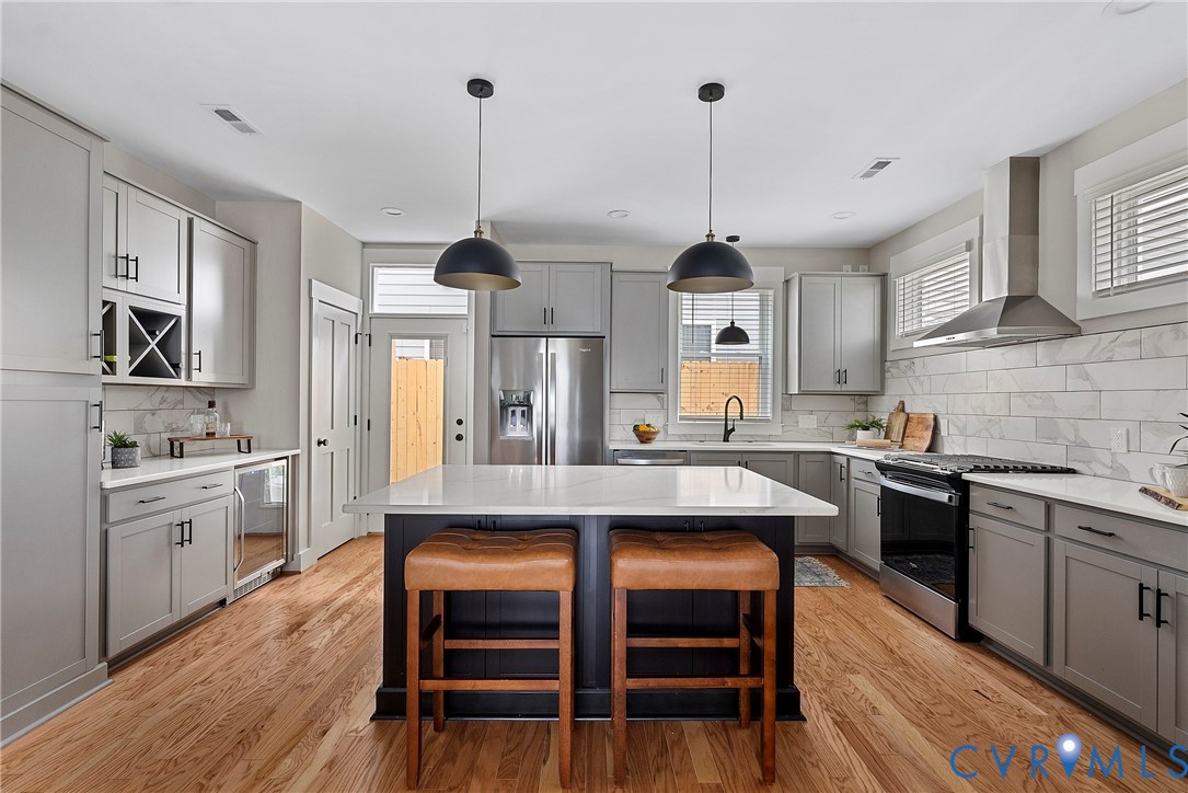 2909 R Street Richmond, VA 23223 - Photo 10 of 50 a kitchen with stainless steel appliances granite countertop a stove a sink dishwasher a refrigerator with white cabinets and wooden floor