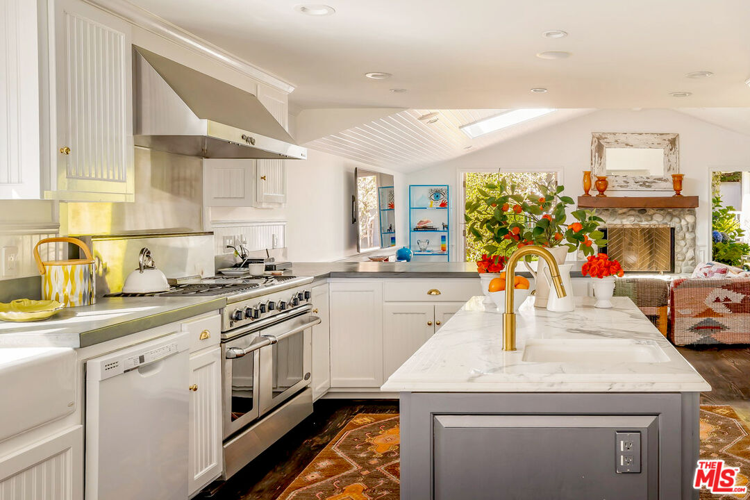 30810 Broad Beach Road Malibu, CA 90265 - Photo 19 of 43 a kitchen with stainless steel appliances granite countertop a sink dishwasher and white cabinets with wooden floor