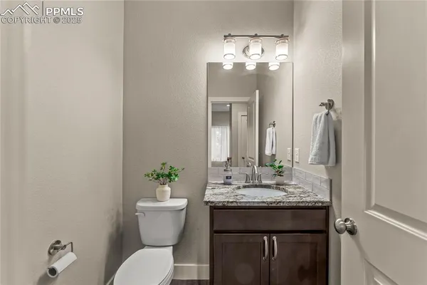 a bathroom with a granite countertop sink a toilet and a mirror