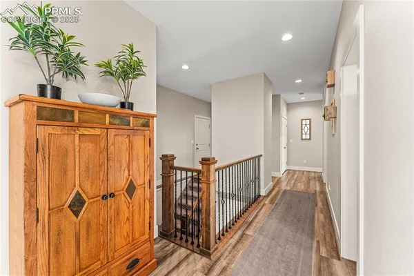 a view of a hallway with wooden floor and staircase