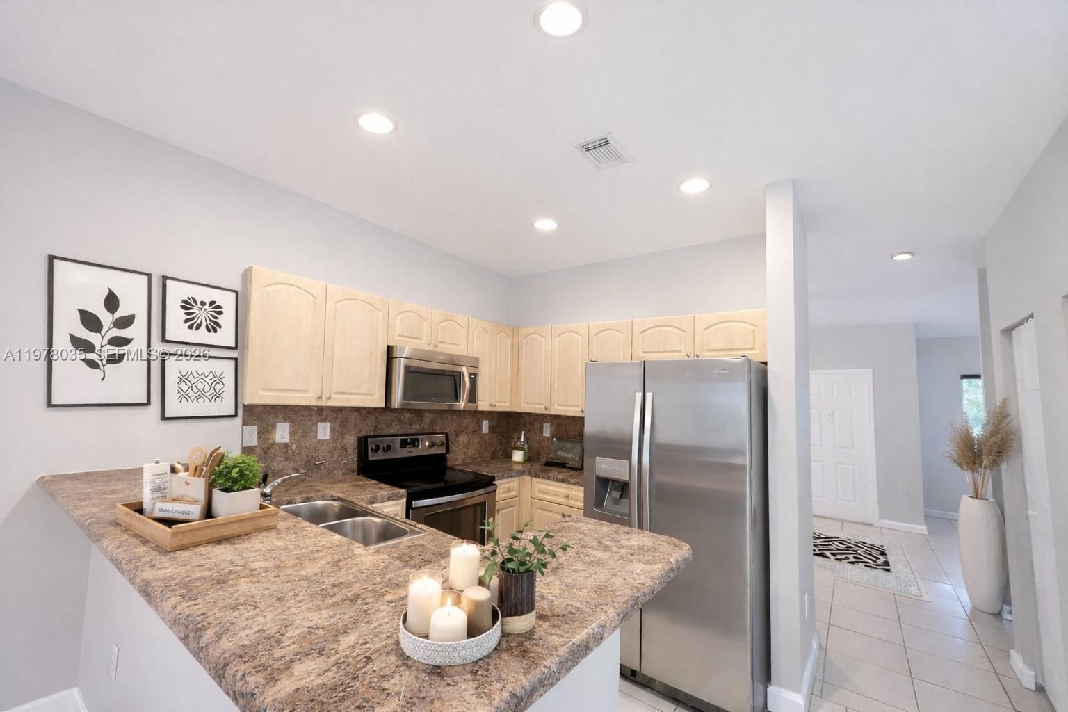 11243 Southwest 230th Terrace Miami, FL 33170 - Photo 2 of 22 a kitchen with stainless steel appliances granite countertop a refrigerator a stove a sink a dining table and chairs