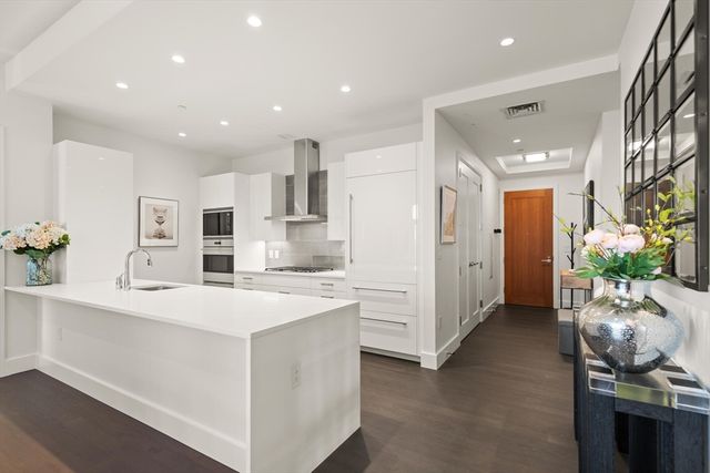 a kitchen with stainless steel appliances kitchen island sink refrigerator and cabinets