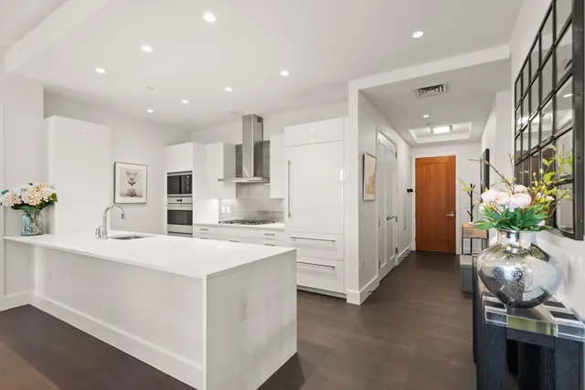 a kitchen with stainless steel appliances kitchen island sink refrigerator and cabinets