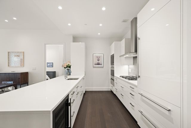 a large white kitchen with stainless steel appliances
