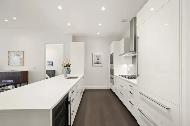 a large white kitchen with stainless steel appliances