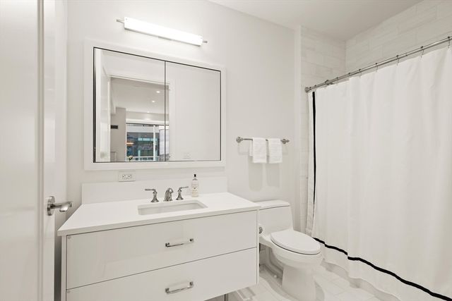 a bathroom with a sink a mirror a toilet and vanity