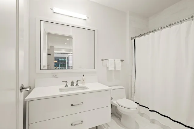 a bathroom with a sink a mirror a toilet and vanity